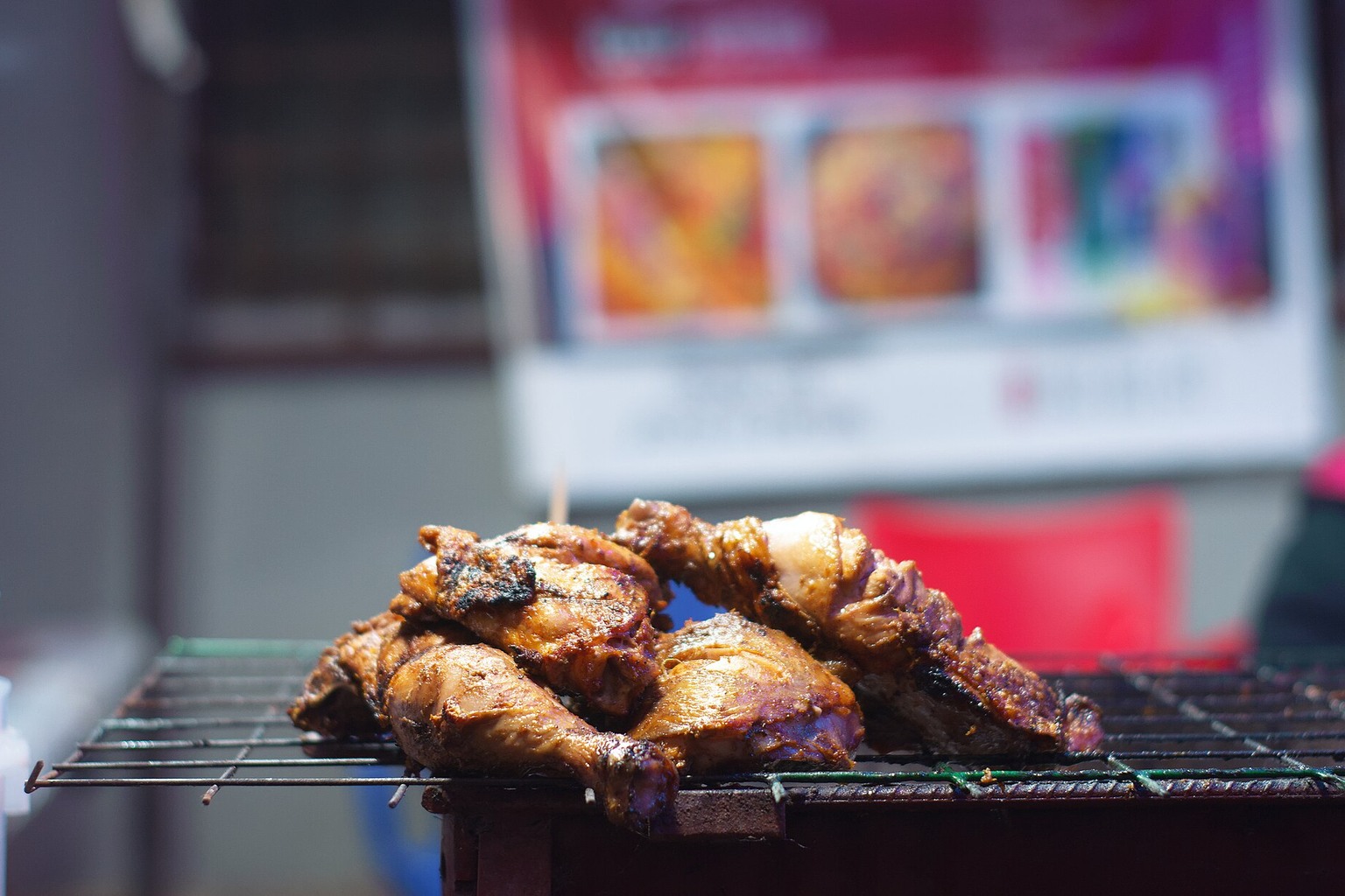 Chicken cooking on a grate; an editorial cooking image, not evidence of wireless controls.
